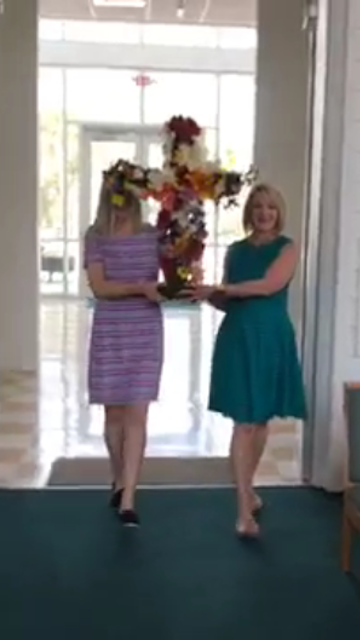 Betty and Mary Catherine carrying flowered cross